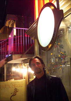 Willie under a backlit, etched glass display on Rue St. Denis, Montreal.